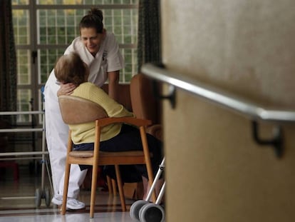 Imatge d'arxiu d'una anciana i una cuidadora en una residència.