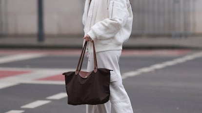 Plano detalle de una mujer llevando un bolso Longchamp.