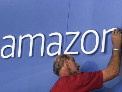 Un hombre ajusta un logotipo de Amazon.