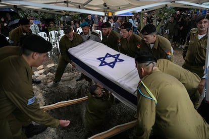 Soldados del ejército israelí descienden el ataúd del sargento Gilad Rozenblit, de 21 años, en el kibutz Ginegar, al norte de Israel, durante su entierro.