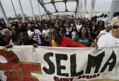 Un grupo de manifestantes avanza sobre el puente con una pancarta que reza "Selma. Domingo Sangriento".