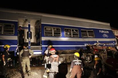 Los bomberos trabajan en uno de los vagones de uno de los trenes siniestrado