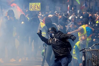 Manifestantes mascarados durante confrontos com a polícia francesa.