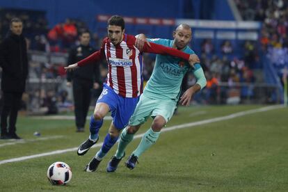 El defensa croata del Atlético de Madrid Sime Wrsaljko (i) pela un balón con el centrocampista del Barcelona Javier Mascherano.