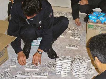 Agentes colombianos clasifican algunos de los billetes de dólar falsificados.