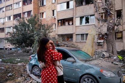 Una mujer consuela a otra frente a una zona afectada por uno de los ataques ruso sobre Kiev.
