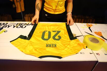 Un trabajador colocando el nombre y número de la australiana Sam Kerr en una camiseta en la tienda de Nike de Sydney.