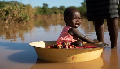 Una madre baña a su hija en agua estancada tras las inundaciones del ciclón 'Idai' en Matarara (Mozambique).