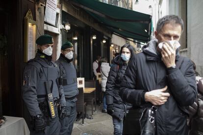 Policías y turistas protegidos con mascarillas por las calles de Venecia, el pasado domingo.