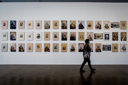 Un hombre camina frente a una serie de retratos de Frederick Douglass en la Bienal de São Paulo.