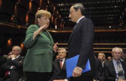 La canciller alemana Angela Merkel (i) conversa con el presidente del Banco Central europeo Mario Draghi (d). EFE/Archivo