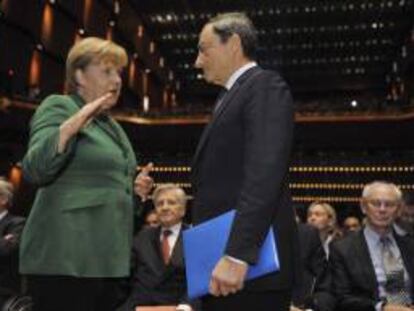 La canciller alemana Angela Merkel (i) conversa con el presidente del Banco Central europeo Mario Draghi (d). EFE/Archivo