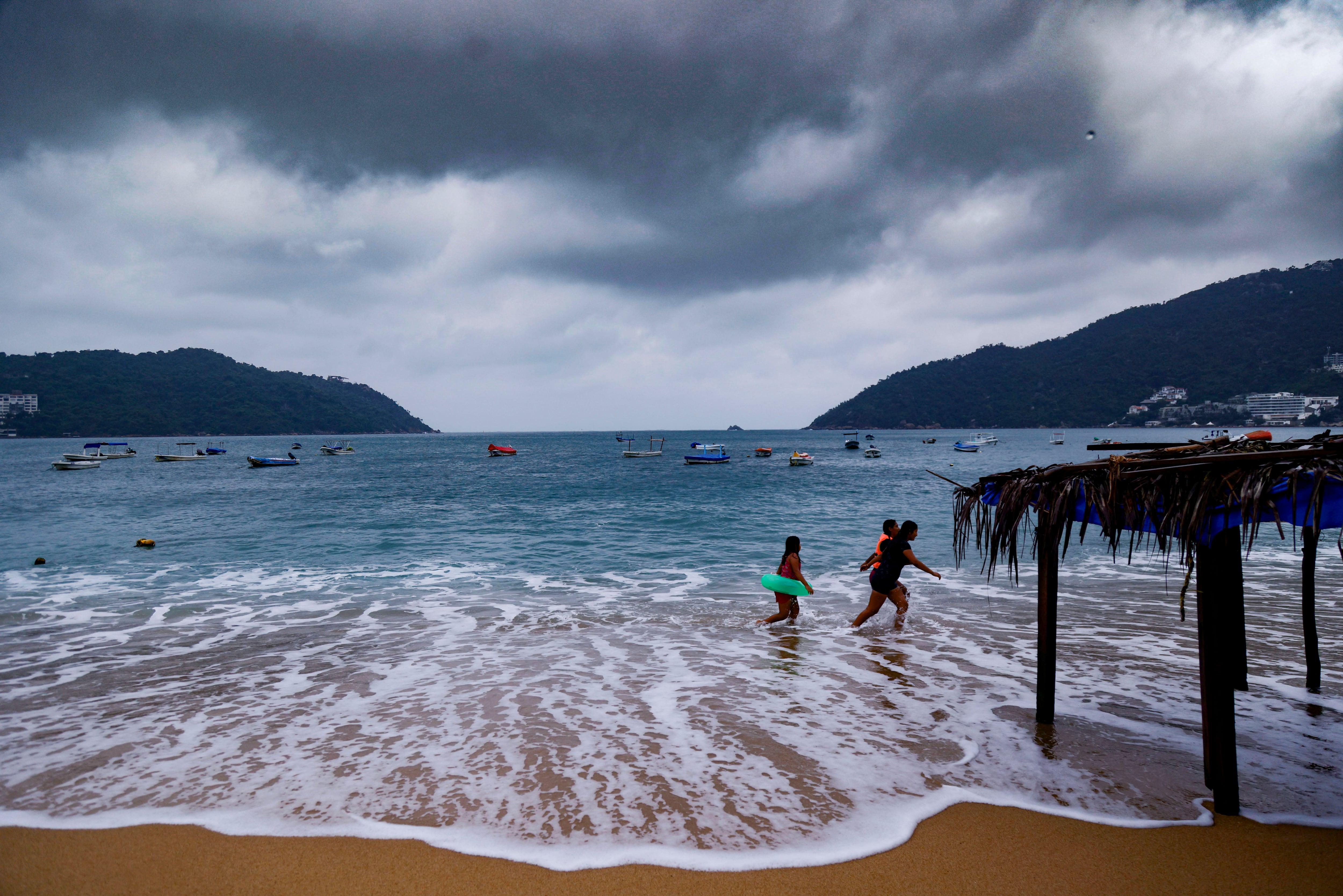 Algunos turistas continúan en la playa pese al clima por el impacto del huracán 'Polo'.
