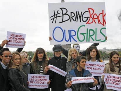 Actrices y modelos francesas posan frente a la Torre Eiffel con pancartas para mostrar su apoyo a la liberación de las niñas secuestradas en Nigeria.