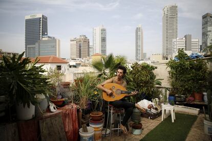 El músico Iyar Semel, de 38 años, toca el laúd en su azotea, que utiliza también como huerto junto con sus dos compañeros de piso.