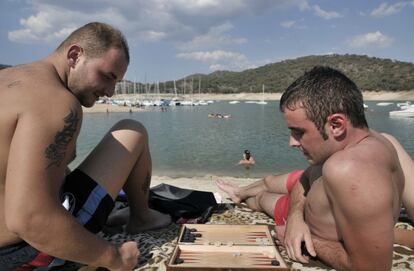 Unos bañistas juegan al backgammon junto al pantano de San Juan en Madrid.