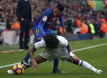 Neymar del FC Barcelona y Marcelo del Real Madrid pelean por el balón.