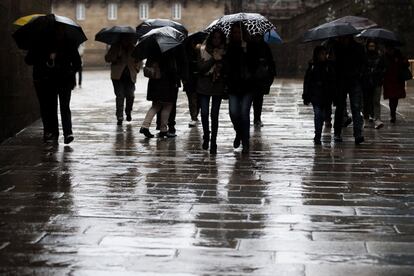 Un grupo de personas se protegen de la lluvia en Santiago de Compostela.