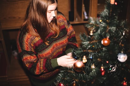 Young woman decorating the Christmas Tree at home