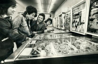 Un grupo de jóvenes juega a las máquinas Pinball.