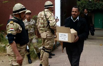 Un egipcio carga una caja con papeletas en un colegio electoral de El Cairo.