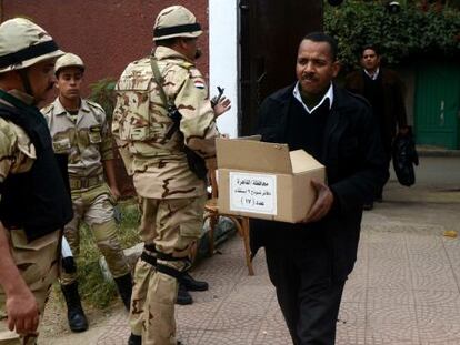 Un egipcio carga una caja con papeletas en un colegio electoral de El Cairo.