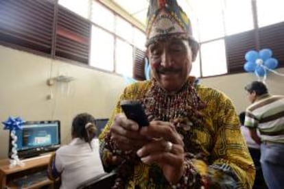 Un hombre que viste un traje tradicional prueba un teléfono móvil durante la inauguración de una biblioteca virtual donada por la empresa Telefónica del Perú, la primera en la ciudad de Yurimaguas en la región Loreto (noreste de Perú).