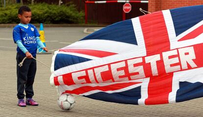 Un pequeño hincha del Leicester con una bandera del equipo de Ranieri en las puertas del estadio. El Leicester, que este domingo jugaba en Old Trafford, empató a uno y será campeón si el Tottenham no ganal al Chelsea. 