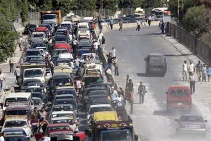 Cientos de vehículos de familias libanesas que regresan al sur del país esperan para cruzar un puente destruido.
