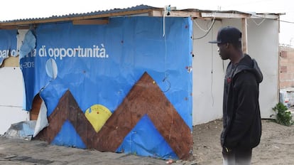 Un hombre observa un barracón de un campo de inmigrantes de Foggia (Italia).