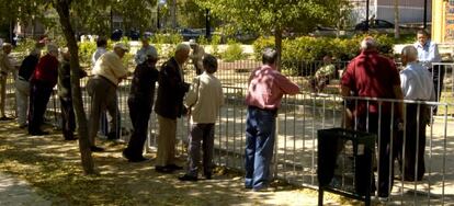 Un grupo de jubilados se reunen en un parque madrileño para jugar a la petanca.