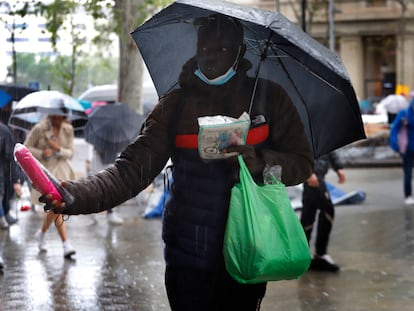 Un vendedor ambulante de paraguas, bajo la lluvia, el pasado 26 de abril en Barcelona.