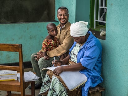 Drocella, agente comunitaria de salud ruandesa, controla la temperatura y hace un test de malaria a un niño de Muguba, el pueblo donde vive.