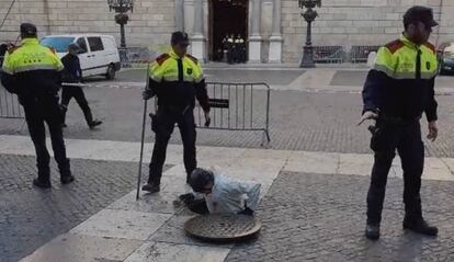 Un agente de la unidad de subsuelo revisa el alcantarillado frente al Palau de la Generalitat.