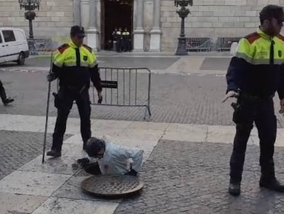 Un agente de la unidad de subsuelo revisa el alcantarillado frente al Palau de la Generalitat.