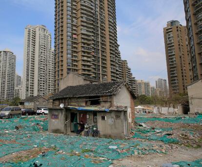 En un rincón de Shanghái, rodeado por una pared de cemento, se encuentra uno de los campos más valiosos del mundo entre escombros y basura. El barrio de Guangfuli es el sueño de un inversionista inmobiliario: una parcela en medio de uno de los mercados inmobiliarios más caros y de rápido crecimiento del mundo. Pero la realidad es más parecida a una pesadilla puesto que cientos de personas que viven allí que se negaron a abandonar sus casas destartaladas durante casi 16 años. En la imagen, Tao Weiren se sienta frente a su casa de dos pisos en el barrio de Guangfuli de Shanghái, el 24 de marzo de 2016.