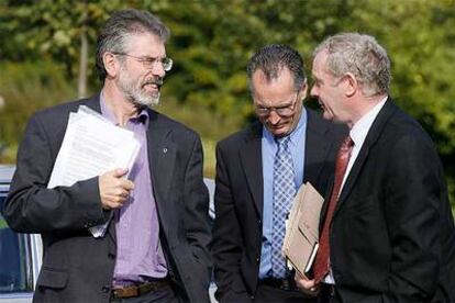 El presidente del Sinn Fein, Gerry Adams (izquierda), habla con dos de sus correligionarios ayer en Stormont.