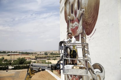 Nychos, subido en la grúa desde la que ha decorado las paredes del silo.