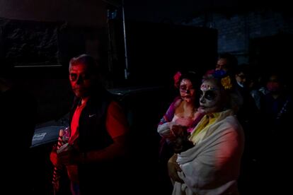 Un hombre maquillado como catrín, y dos mujeres como catrinas, en las calles de Ocotepec.