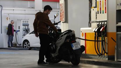 Un motorista reposta con su moto en una gasolinera de Madrid.