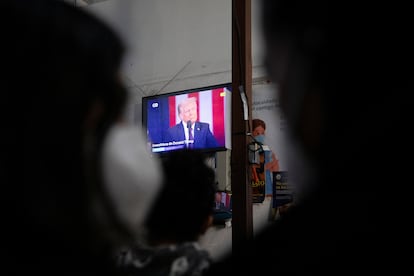 Migrantes que buscan asilo en Estados Unidos observan el discurso de investidura del presidente estadounidense Donald Trump, en el albergue para migrantes Juventud 2000, en Tijuana.