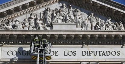 Los bomberos preparan los anclajes del baldaquino para la sesión de apertura de la XII legislatura.