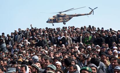 Un helic&oacute;ptero del ej&eacute;rcito afgano sobrevuela a un grupo afganos que asisten al entierro del Vicepresidente Mohammad Qasim Fahim, en Kabul (Afganist&aacute;n). 