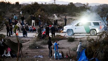 Un agente de la Patrulla Fronteriza de Estados Unidos observa a un grupo de solicitantes de asilo en un campamento después de cruzar la cercana frontera con México, cerca de Jacumba, (California)