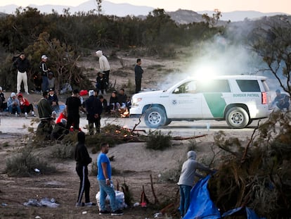 Un agente de la Patrulla Fronteriza de Estados Unidos observa a un grupo de solicitantes de asilo en un campamento después de cruzar la cercana frontera con México, cerca de Jacumba, (California)