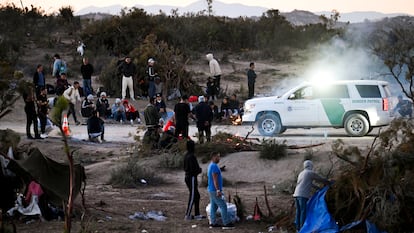 Un agente de la Patrulla Fronteriza de Estados Unidos observa a un grupo de solicitantes de asilo en un campamento después de cruzar la cercana frontera con México, cerca de Jacumba, (California)
