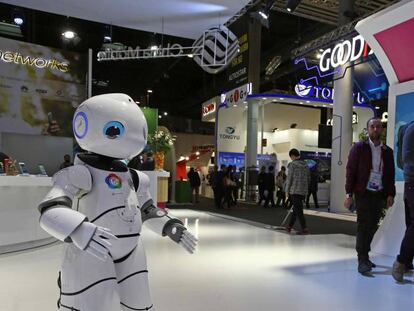 Visitantes de la pasada edición del Congreso Mundial de Móviles observan los movimientos de un robot.