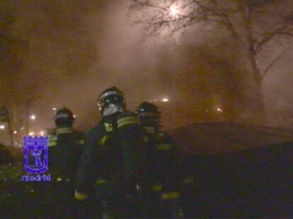 Unos bomberos observan el incendio de la calle de José Bergamín, en Moratalaz.