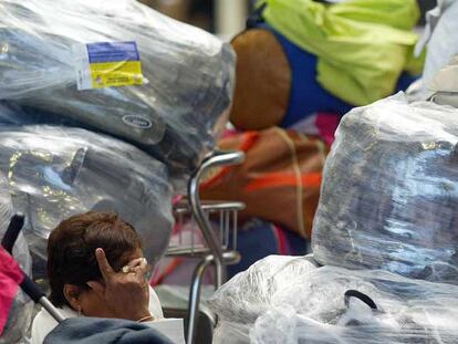 Una viajera ecuatoriana, con gesto de desesperación, en el aeropuerto de El Prat.