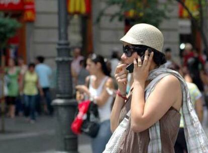 Una mujer habla por un teléfono móvil en el centro de Madrid.